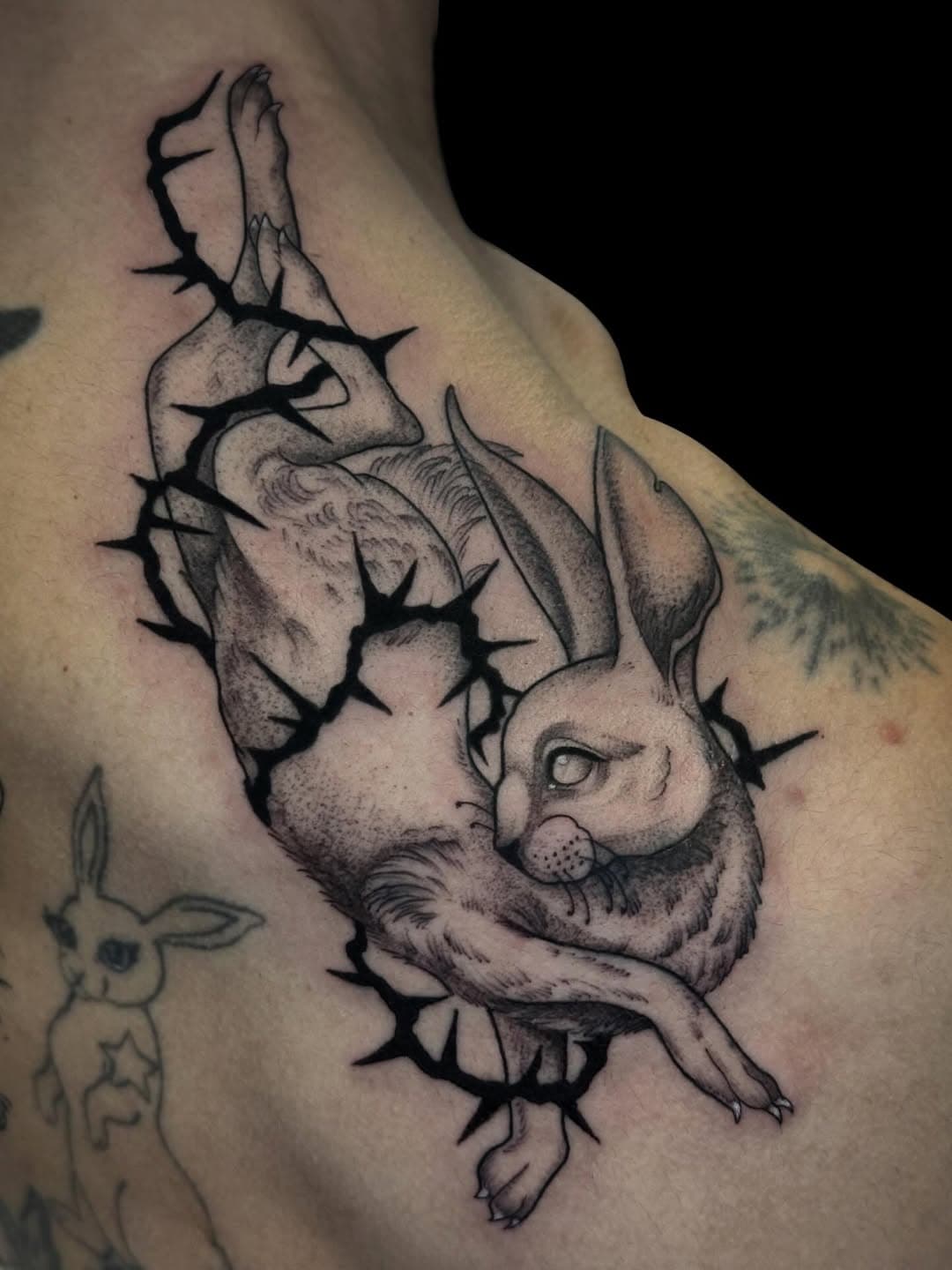 Rabbit tattoo wrapped within barbed wire