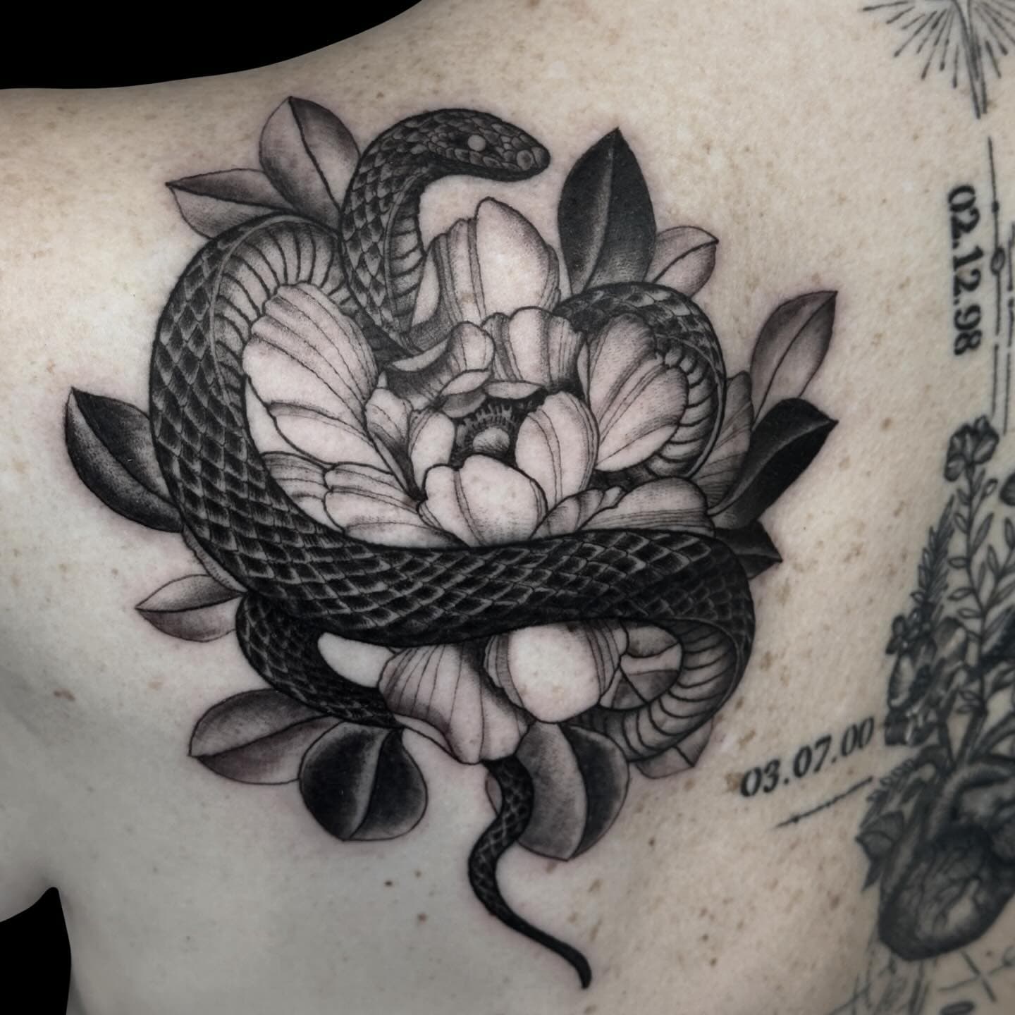 Tattoo of a snake wrapping around a peony