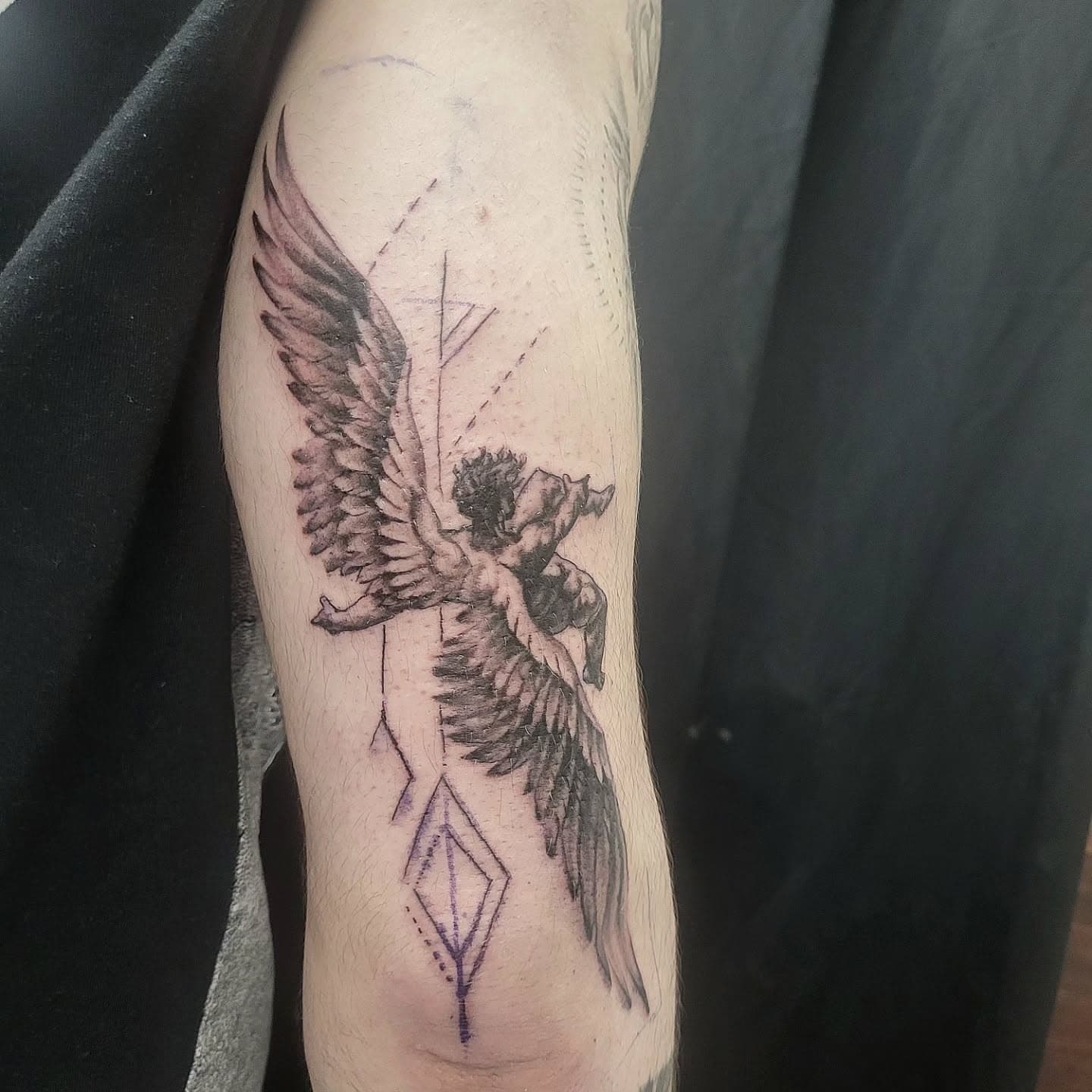 Tattoo of a falling angel with an arrow through the heart.